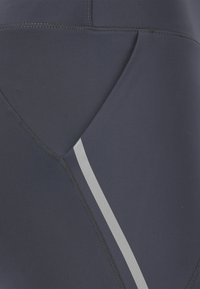 Pantaloni sportivi blu navy con finitura texturizzata, dotati di una striscia diagonale argento e cuciture rinforzate lungo le cuciture.