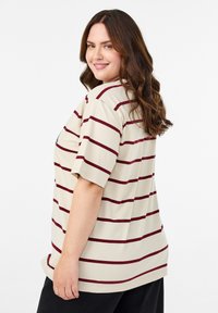Beige short-sleeve T-shirt with maroon horizontal stripes. Features a relaxed fit and a round neckline. Soft fabric with smooth texture.