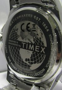 Fonds de montre en acier inoxydable avec une surface noire arborant un design de carte du monde, "Timex", et les détails de la Collection Essex Avenue.