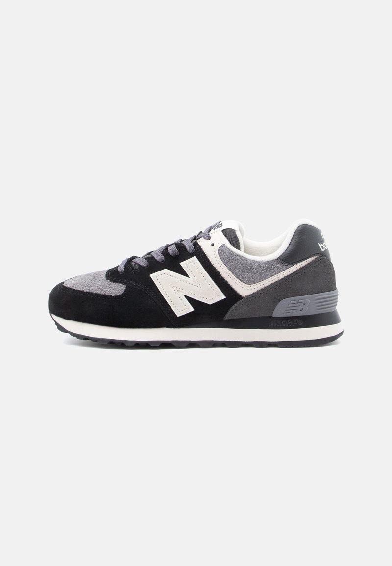 Čierne, sivé a biele tenisky New Balance so semišovými a sieťovinovými panelmi, bielym logom "N" a textúrovanou gumovou podrážkou.