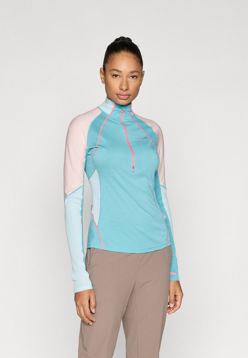 Ελαφρύ μπλουζάκι μακρυμάνικο σε τιρκουάζ χρώμα με ανοιχτό ροζ και μπλε λεπτομέρειες, με φερμουάρ στο λαιμό και αντίθετες ραφές.