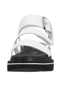 White sandals with multiple wide straps, adjustable buckle, and a black outsole with white trim; features a smooth leather-like texture.