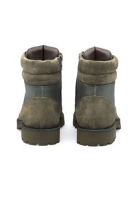 Stivaletti alla caviglia in camoscio verde con finitura testurizzata, caratterizzati da un colletto pieghevole e cerniere laterali per facilitare la calzata. Suola in gomma chunky per una buona aderenza.