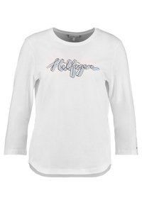 T-shirt bianco a maniche lunghe con scollatura rotonda, caratterizzato da un logo "Hilfiger" multicolore in corsivo sul petto. Tessuto di cotone morbido.