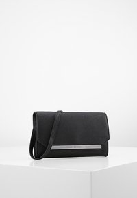 Schwarze Leder-Crossbody-Tasche mit strukturiertem Finish, silbernen Hardware-Akzenten und einem umklappbaren Klappverschluss. Kompakte und strukturierte Form.