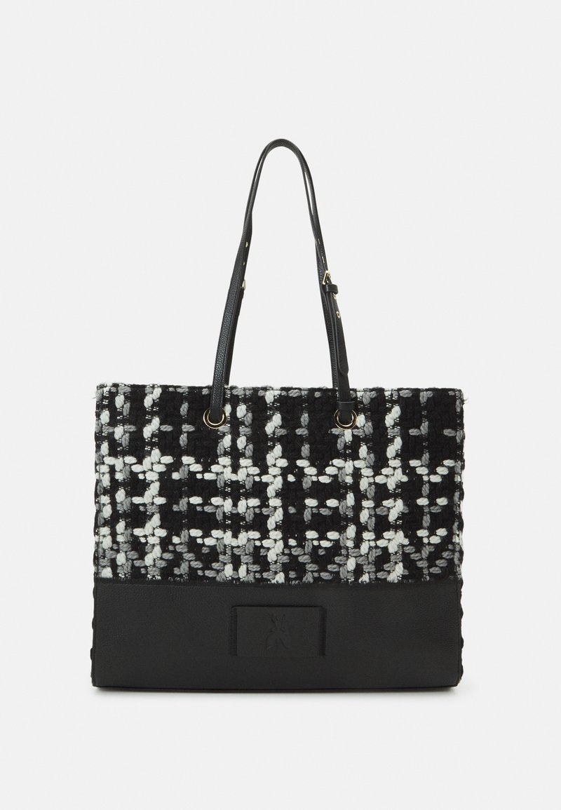 Sac fourre-tout avec un motif tissé texturé noir et blanc et un fond en cuir noir lisse. Comprend de longues anses et un logo discret.