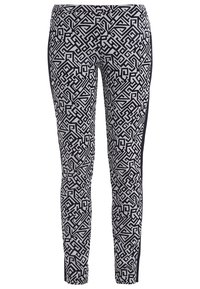 Svart- och vitmönstrade leggings med geometriska mönster, tillverkade av stretchigt tyg, med en slim fit och sidopaneler i enhetligt svart.