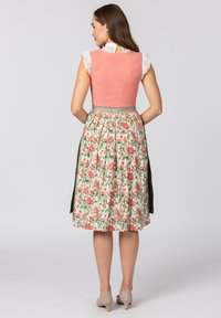 Traditionelles Kleid mit einem enganliegenden, pinkfarbenen Mieder mit Rautenmuster und Spitzensäumen. Der Rock hat ein florales Muster in Rot und Grün.