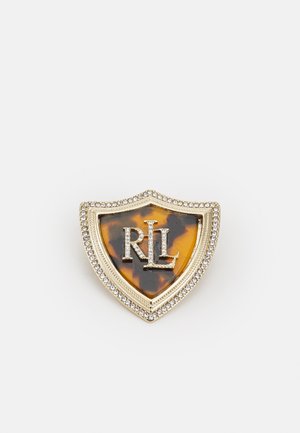 Broche in de vorm van een schild met een middenstuk van schildpadmotief, een rand in goudkleur met heldere kristallen, en in het midden de initialen "RL" bezet met strass steentjes.
