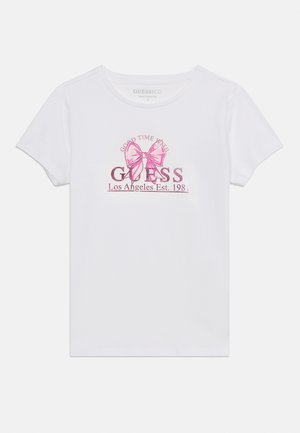 Hvit t-skjorte med korte ermer, rosa sløyfe-trykk og teksten "Good Time With Guess Los Angeles Est. 1981" på forsiden.