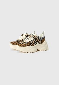 Sapatilhas com padrão de leopardo, com uma sola grossa em creme, apresentando detalhes pretos, fecho de atacadores e puxadores no calcanhar para fácil colocação.