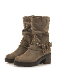 Botas de tobillo de ante marrón con un diseño arrugado, detalles trenzados, correa decorativa y un tacón grueso para mayor altura y estabilidad.