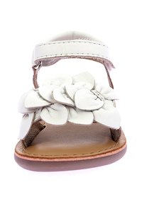 Sandali bianchi in pelle con suola piatta, dotati di un design floreale sulla cinghia e chiusura in velcro per una facile regolazione.