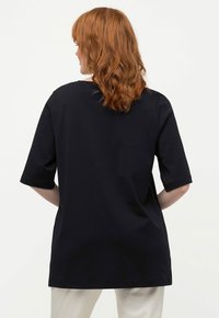 Navy kortærmet t-shirt med rund halsudskæring og løs pasform, lavet af blødt stof. Har en lige skæring og minimale syninger.