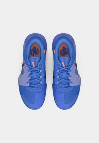 Μπλε αθλητικά παπούτσια με ύφασμα από δίχτυ, υφασμένα πάνελ, μαύρες λεπτομέρειες και πορτοκαλί πινελιές. Σχεδιασμένα για απόδοση και άνεση.