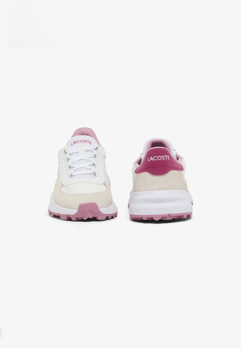 Sneakers Lacoste in bianco e rosa chiaro, caratterizzate da una combinazione di materiali in mesh e suede, con una suola in gomma testurizzata e il marchio sul tallone.