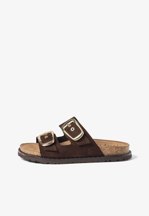 Brown suede slide sandal with two adjustable gold-tone buckles and cork footbed on a black rubber sole.