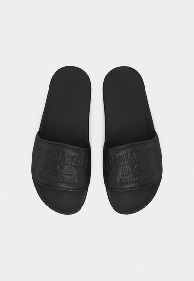 Μαύρα σανδάλια χωρίς λουράκια με εντυπωμένα τα γράμματα "DSQUARED2 Rebels EST. SINCE 1995" στα μπροστινά λουράκια, εμφανίζονται από πάνω σε λευκό φόντο.