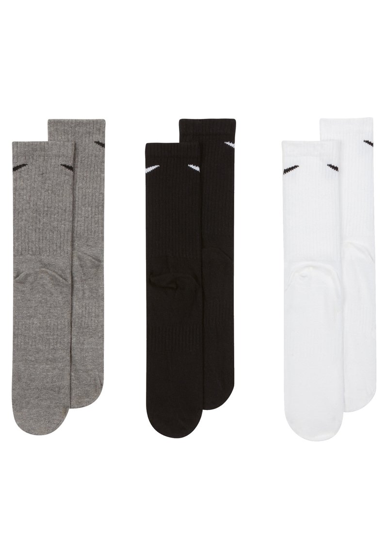 Tres pares de calcetines hasta la rodilla: uno gris, uno negro y uno blanco, cada uno con textura acanalada y acentos de talón y puntera en contraste.
