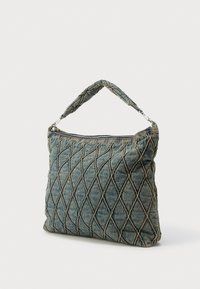 Torbica od prošivene tkanine tamnoplave boje s uzorkom dijamanata. Ima kratku, uvrnutu ručku i zatvaranje na patentni zatvarač na vrhu.