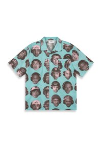 Short-sleeve shirt in teal with repeated black-and-pink faces, featuring patterns and button-down front.  Cotton material with a relaxed fit.