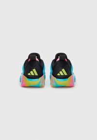 Chaussures de sport noires et bleues avec des semelles à dégradé multicolore, présentant un accent rose et trois bandes jaunes sur le talon.