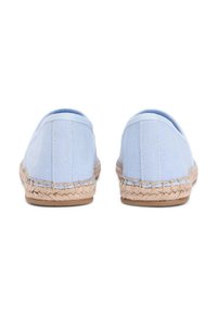 Espadrilles en tissu bleu avec tige en toile, détail en corde de jute le long de la semelle, et semelle extérieure en caoutchouc plate. Vue arrière montrant une couture simple.