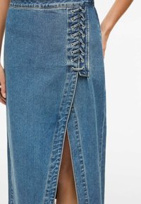 Jeansrock mit Schnürdetail an der Seite, Vorderschlitz sowie hellblauer Farbe mit dezentem Textur- und Näherelementen.