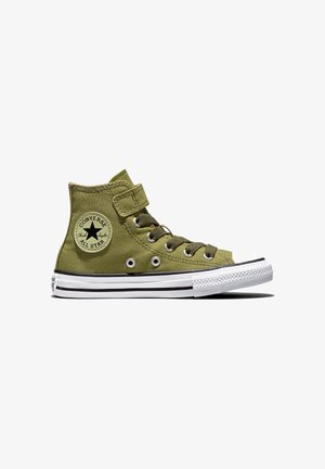 Basket montante Converse All Star vert olive avec semelle en caoutchouc blanche, détails noirs, lacets et bride à la cheville sur fond blanc.