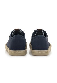 Zapatillas de lona azul marino con superficie texturizada, puntera redonda y suela de yute. Un detalle de cuero marrón en el talón agrega estilo.