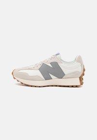 Zapatillas con parte superior de cuero blanco, detalles de gamuza gris y suela de goma; cuenta con un logotipo "N" texturizado en gris y diseño de cordones.
