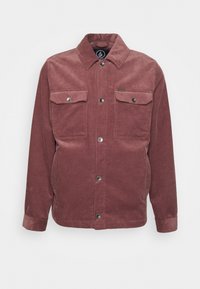 Corduroy jack in gedempt bordeaux met een kraag, twee borstzakken en drukknoopsluitingen. Gelaagd stof met verticale strepen.