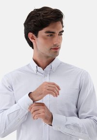 Knopfhemd mit vertikalen blauen und weißen Streifen, aus leichtem Stoff, mit Tasche und Knopfmanschetten.