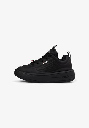 Zapatilla deportiva negra con una parte superior lisa de material sintético, suela de goma gruesa, cierre de cordones prominente, cuello acolchado y acentos del logo de Fila.