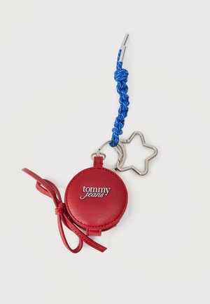 Rødt rundt læder nøglering med "tommy jeans" logo, blå flettet snor, metal stjerneformet ring og rød læder sløjfe detalje.
