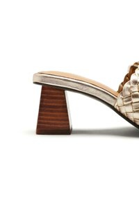 Chaussure slip-on en cuir tissé doré métallisé avec un talon en bois triangulaire. Texture lisse et design à bout ouvert.