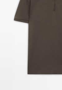 Kortærmet mørkebrun polo med lynlåslukning ved kraven, vist mod en hvid baggrund.