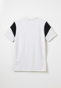Camiseta blanca de manga corta con detalles en negro en los hombros. Material ligero, cuello redondo, textura suave, diseño limpio, sin patrones visibles.