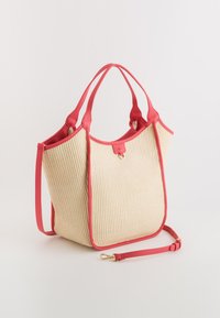 Tote bag with a textured cream body and pink leather accents. Features two handles and an adjustable shoulder strap.
