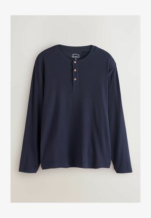 Mornarica dugačka majica s dugim rukavima, okruglim izrezom, plaketom s tri gumba, rebrastom teksturom i ravnim rubom. Napravljena od prozračnog materijala.