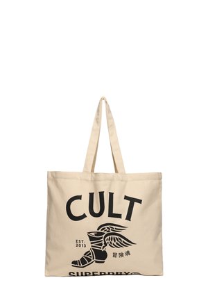Borsa a spalla in tela beige con caratteri neri in bold "CULT" e un'illustrazione di un stivale alato. Tessuto resistente e lunghe cinghie per un facile trasporto.