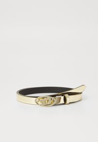 Ceinture en métal doré avec une finition lisse et brillante, dotée d'une boucle ovale et d'une sangle en cuir noir. Le design est minimaliste avec des lignes épurées.