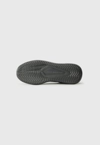 Suela de zapato de goma negra con patrón en espiga texturizado. Presenta el nombre de la marca grabado y bordes suaves, diseñada para ofrecer tracción y estabilidad.