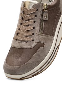 Brauner und beiger Sneaker aus Leder und Wildleder mit beigen Schnürsenkeln, goldenem Reißverschluss an der Seite und weißer Gummisohle.