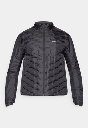 Casaco preto puff com fecho à frente, gola alta e logótipo azul no peito. Tecido liso e brilhante com textura acolchoada e bolsos laterais.