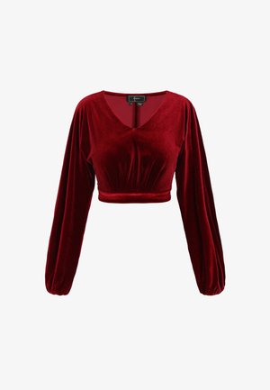 Roodfluwelen cropped top met lange mouwen, diepe V-hals, gedetailleerde geplooide taille en zachte textuur. Gecombineerd met een subtiele glansafwerking.