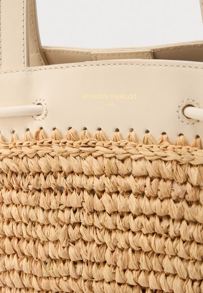 Μπεζ πλεκτή ψάθινη τσάντα ώμου με μπεζ δερμάτινες λεπτομέρειες και χρυσό λογότυπο "Claudie Pierlot Paris" στην επάνω δερμάτινη επιφάνεια.