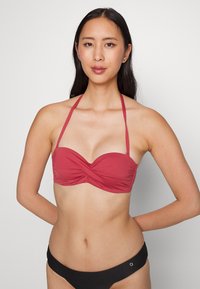 Top bikini color borgogna, con un design frontale attorcigliato, spalline regolabili e una consistenza liscia. Abbinato a slip bikini neri.