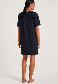 Abito corto in cotone blu navy con vestibilità comoda, scollatura a girocollo e maniche corte; l'orlo arriva a metà coscia, senza motivi o dettagli visibili.