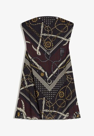 Crna haljina bez naramenica s crvenim točkicama, bijelim remenjem, zlatnim lancima, pomorskim užadima i uzorcima upravljača broda.